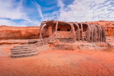 a building in the desert with some stairs in it at Wadi Rum Cave Camping in Wadi Rum