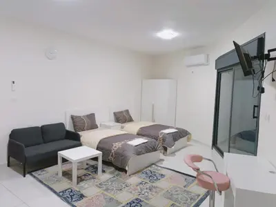 a living room with two beds and a couch at For Women Only - للنساء فقط in Umm el ‘Amad