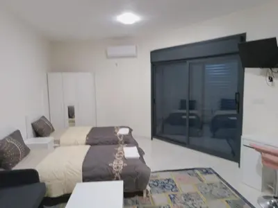 a bedroom with a bed and a large sliding glass door at For Women Only - للنساء فقط in Umm el ‘Amad