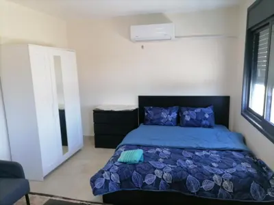 a bedroom with a bed with a blue comforter at Durrat Al Israa in Umm el ‘Amad