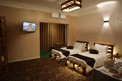 a hotel room with two beds and a flat screen tv at Petra Wooden House in Wadi Musa