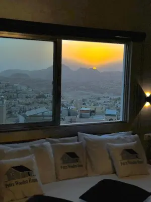 a bedroom with a window with a view of a city at Petra Wooden House in Wadi Musa