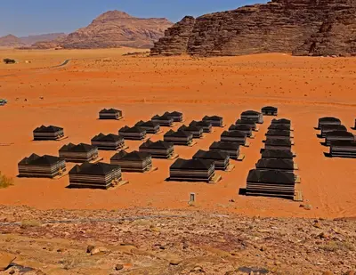 a row of black chairs in the desert at SunCity Camp in Wadi Rum