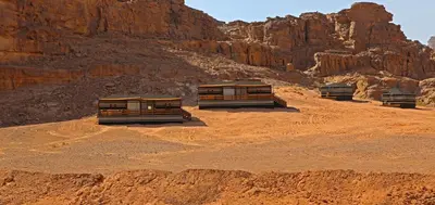 three trucks parked in a desert with a mountain at SunCity Camp in Wadi Rum