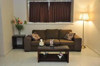 a living room with a couch and a table at Bashtamal Hotel Suites in Amman