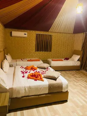 two beds in a room with flowers on them at Sunrise Luxury Camp in Wadi Rum