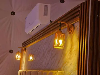 a bathroom with three lights on the wall at Sunrise Luxury Camp in Wadi Rum