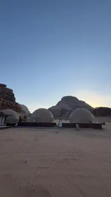 three domes in the desert with mountains in the background at Rehana rum luxury camp in Wadi Rum