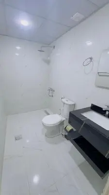 a white bathroom with a toilet and a sink at Rehana rum luxury camp in Wadi Rum