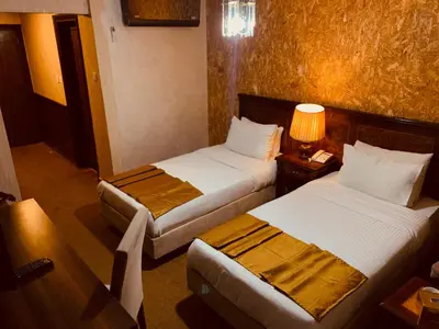 a hotel room with two beds and a lamp at Amman Orchid Hotel in Amman