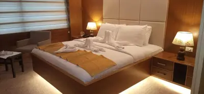a bedroom with a bed with white sheets and pillows at Amman Orchid Hotel in Amman