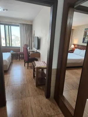 a hotel room with a bed and a mirror at Amman Orchid Hotel in Amman