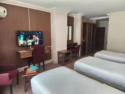 a hotel room with two beds and a flat screen tv at Amman Orchid Hotel in Amman