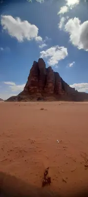 a large rock formation in the desert on a beach at Wadi Rum albasli in Wadi Rum