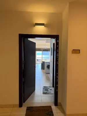 a hallway with a door open to a room with the ocean at Rental unit in RAHA village compound, special view in Aqaba