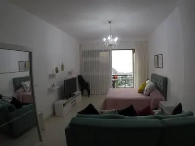 a bedroom with a bed and a couch and a mirror at Rental unit in RAHA village compound, special view in Aqaba