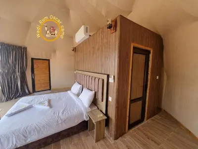 a bedroom with a bed and a sign on the wall at Wadi Rum Oscar camp in Wadi Rum