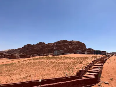 a pathway in the desert with a mountain in the background at Art Camp Wadi Rum in Wadi Rum