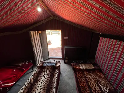 two beds in a room with a red ceiling at Art Camp Wadi Rum in Wadi Rum