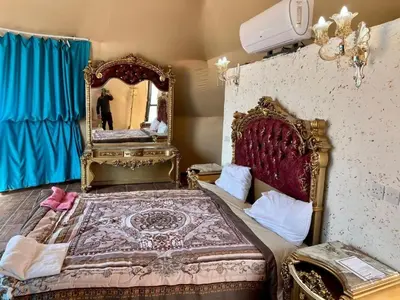 a bedroom with a large bed and a mirror at Sun rise wadi rum camp in Wadi Rum