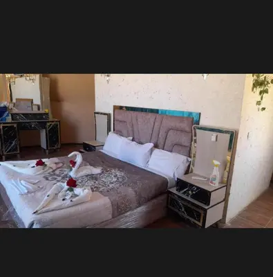 a bedroom with a large bed and a laptop computer at Sun rise wadi rum camp in Wadi Rum