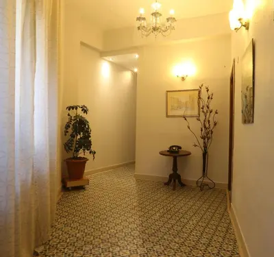 a hallway with a potted plant and a table at فندق الريفييرا in Ash Shumaysānī