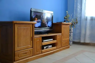 a tv sitting on top of a wooden entertainment center at Only FAMILIES - Tala Bay Resort Aqaba - Seafront one bedroom apartment in Aqaba