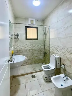 a bathroom with a sink and a toilet and a shower at Only FAMILIES - Tala Bay Resort Aqaba - Seafront one bedroom apartment in Aqaba