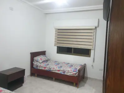 a small bedroom with a bed and a window at شقة مفروشة فرش فاخر ٣ غرف نوم في طبربور عمان in Amman