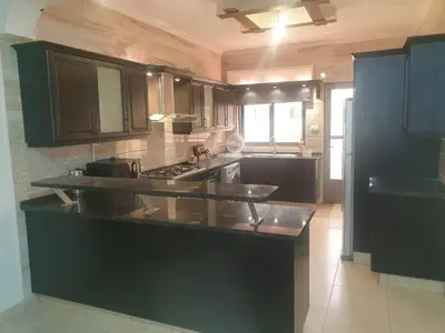 a kitchen with black cabinets and a black counter top at شقة مفروشة فرش فاخر ٣ غرف نوم في طبربور عمان in Amman