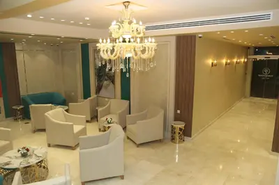 a room with chairs and tables and a chandelier at Turquoise Hotel in Aqaba