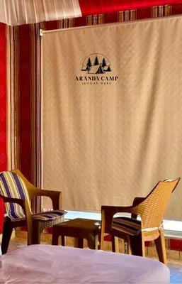 two chairs and a table in front of a screen at Rum Aranda camp &Bubbles Hotel in Wadi Rum