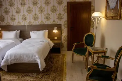 a bedroom with a bed and a chair and a table at Khan Khediwe Hotel in Amman