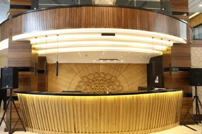 a lobby with a large wooden wall with a circular ceiling at فندق صحارى الخليج Sahara Gulf Hotel Apartments in Amman