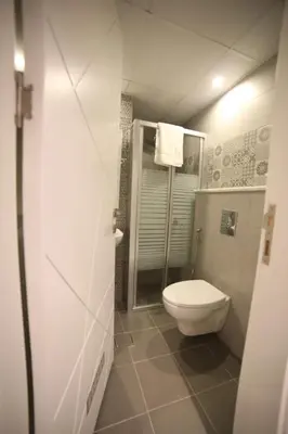 a small bathroom with a toilet and a shower at فندق صحارى الخليج Sahara Gulf Hotel Apartments in Amman