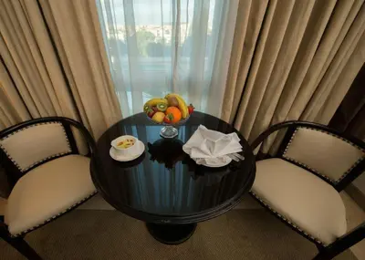 a table and two chairs with a bowl of fruit on it at Century Park Hotel in Amman