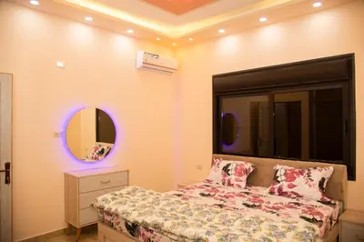 a bedroom with a bed and a mirror at Lotus housing for furnished apartments in Jerash