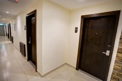a hallway with a wooden door in a building at AQABA COAST HOTEL in Aqaba