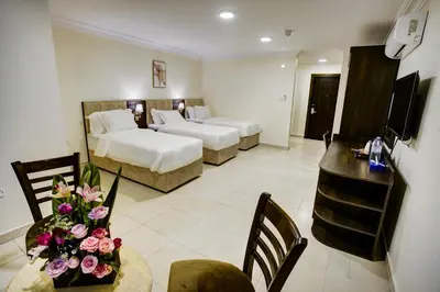 a hotel room with two beds and a table with flowers at AQABA COAST HOTEL in Aqaba
