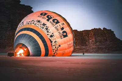 a large orange and black balloon on the beach at Wadi Rum Mirror Camp in Wadi Rum