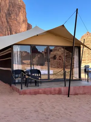 a tent with a table and chairs in the desert at Wadi Rum Mirror Camp in Wadi Rum