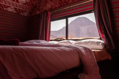 a bed in a room with a view of a mountain at Bedouin Yoga & Trekking Camp Wadi Rum in Wadi Rum