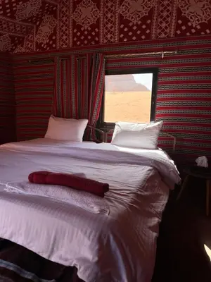 a bedroom with a large bed and a window at Bedouin Yoga & Trekking Camp Wadi Rum in Wadi Rum