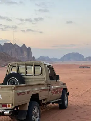 a pick up truck parked in the desert at rum rema camp in Wadi Rum