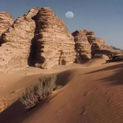 a view of the desert with the moon in the background at Wadi Rum Trail in Wadi Rum