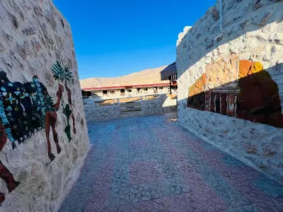a stone wall with paintings on it next to a building at Petra Royal Ranch in Wadi Musa