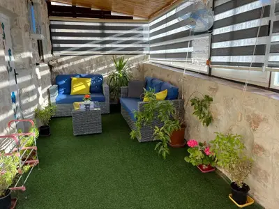 a balcony with chairs and a table and plants at Petra Royal Ranch in Wadi Musa