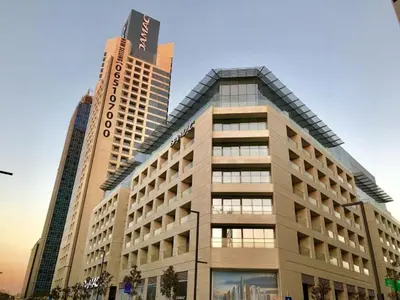 a large building in front of two tall buildings at Amazing Studio in DAMAC in Amman
