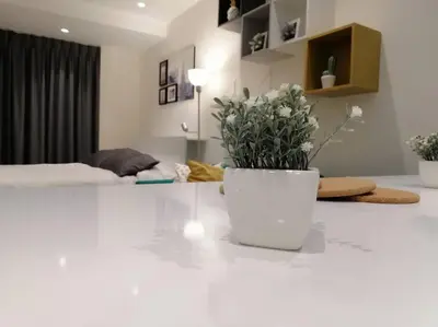 a white room with a vase with flowers on a counter at Amazing Studio in DAMAC in Amman