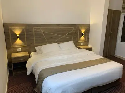 a bedroom with a large white bed with two lamps at Asad Apt. in Wadi Musa